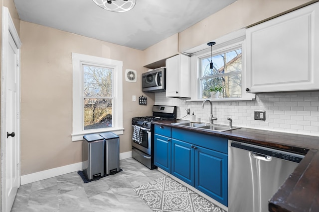 kitchen featuring sink, stainless steel appliances, white cabinets, and blue cabinetry