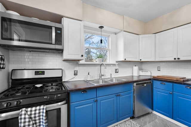 kitchen featuring blue cabinetry, sink, wooden counters, appliances with stainless steel finishes, and white cabinets