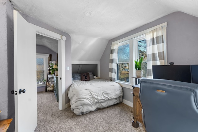 bedroom with light colored carpet, vaulted ceiling, and a textured ceiling