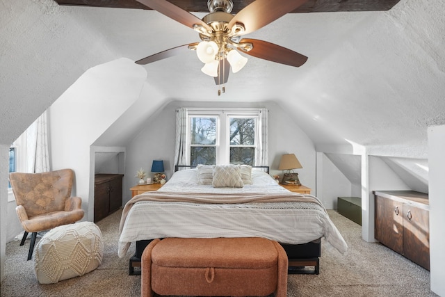 carpeted bedroom with ceiling fan, vaulted ceiling, and a textured ceiling