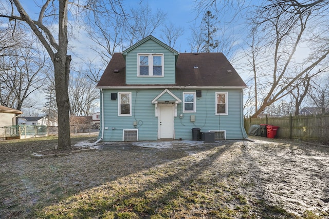 rear view of property featuring a lawn and central air condition unit