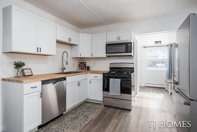 kitchen featuring white cabinets, appliances with stainless steel finishes, sink, and wooden counters