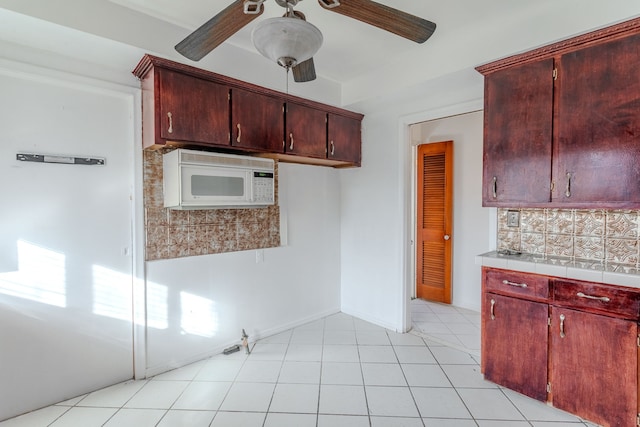 kitchen featuring light tile patterned flooring, ceiling fan, and decorative backsplash