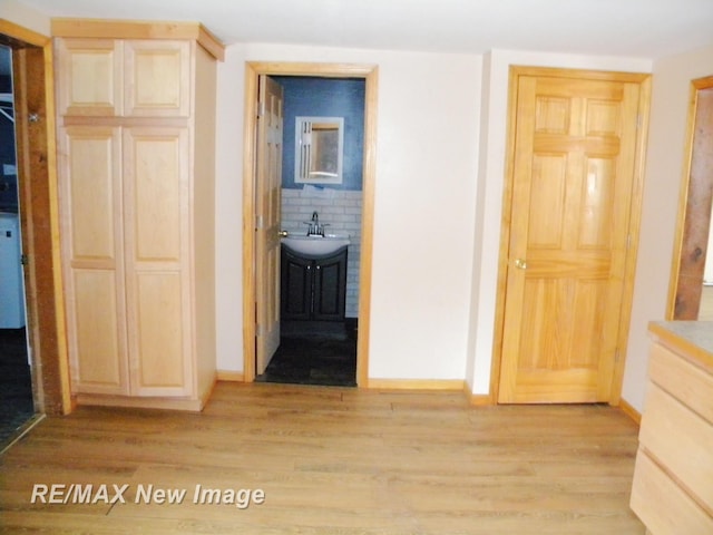 hallway featuring sink and light hardwood / wood-style floors