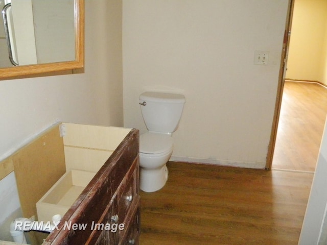 bathroom with hardwood / wood-style flooring, vanity, and toilet