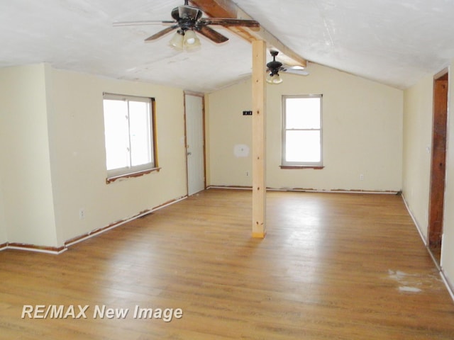 unfurnished room with lofted ceiling with beams, ceiling fan, and light wood-type flooring