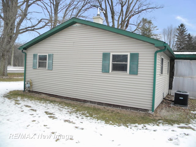 view of snowy exterior featuring central AC unit