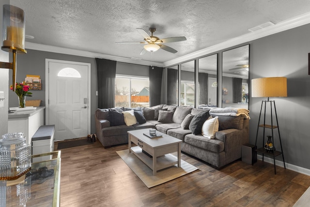 living room featuring dark hardwood / wood-style flooring, crown molding, a textured ceiling, and ceiling fan