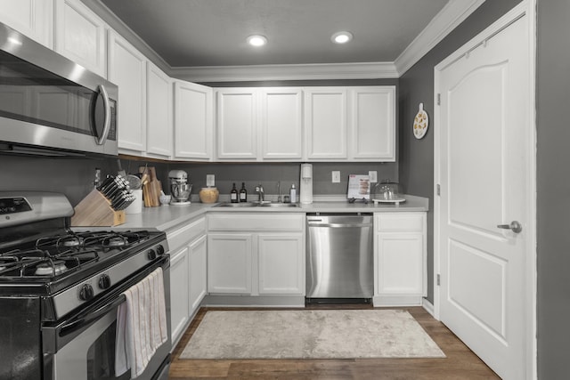 kitchen with crown molding, stainless steel appliances, sink, and white cabinets