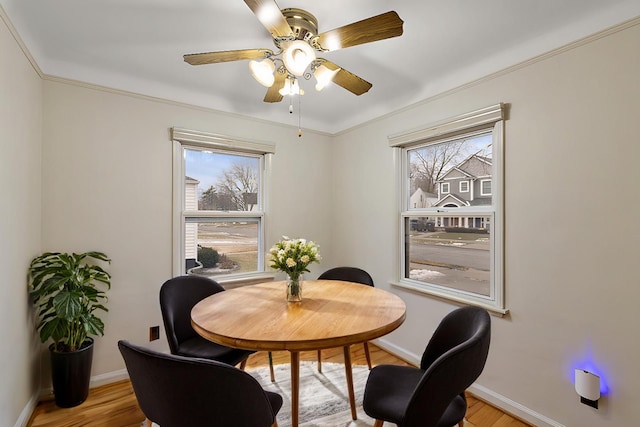 dining space featuring crown molding, plenty of natural light, and light hardwood / wood-style floors