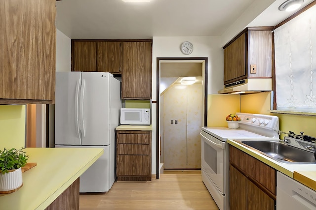 kitchen with white appliances, light hardwood / wood-style floors, and sink