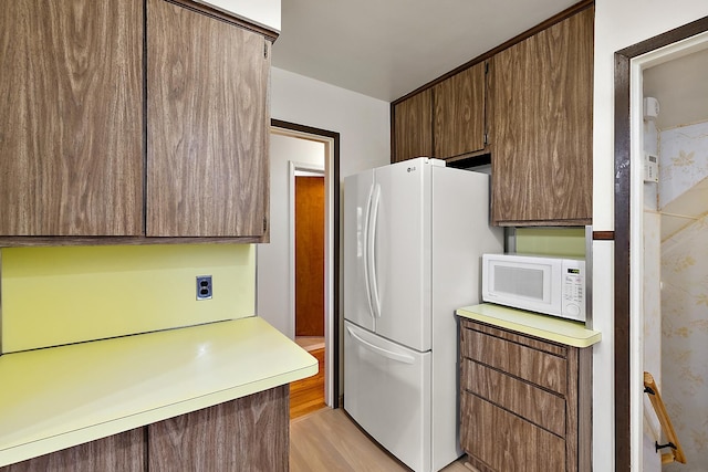 kitchen with white appliances and light wood-type flooring