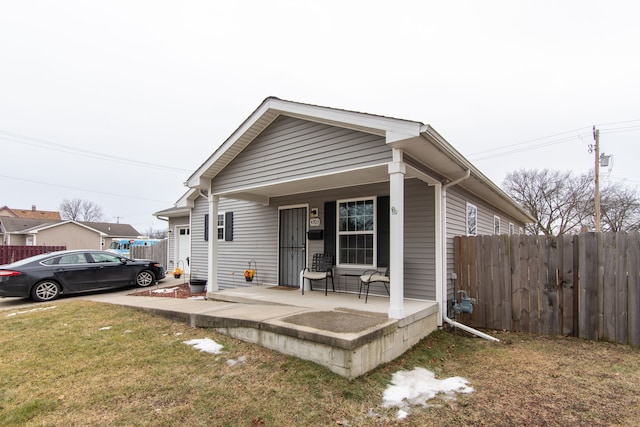 bungalow-style house with a porch and a front lawn