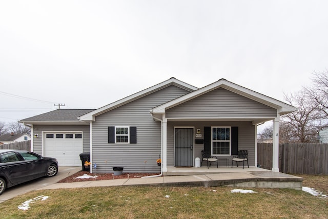 view of front of house with a garage, a front yard, and a porch