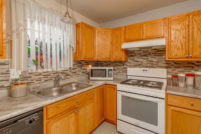 kitchen with white appliances, sink, hanging light fixtures, and backsplash