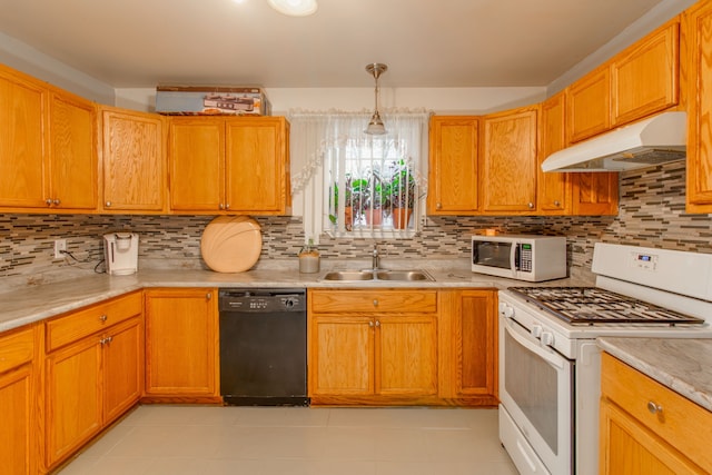 kitchen featuring pendant lighting, white appliances, sink, and backsplash