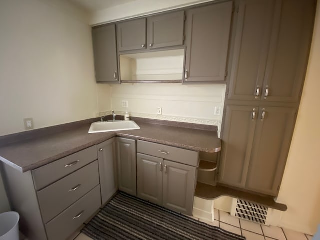 kitchen featuring sink, gray cabinetry, and dark tile patterned flooring