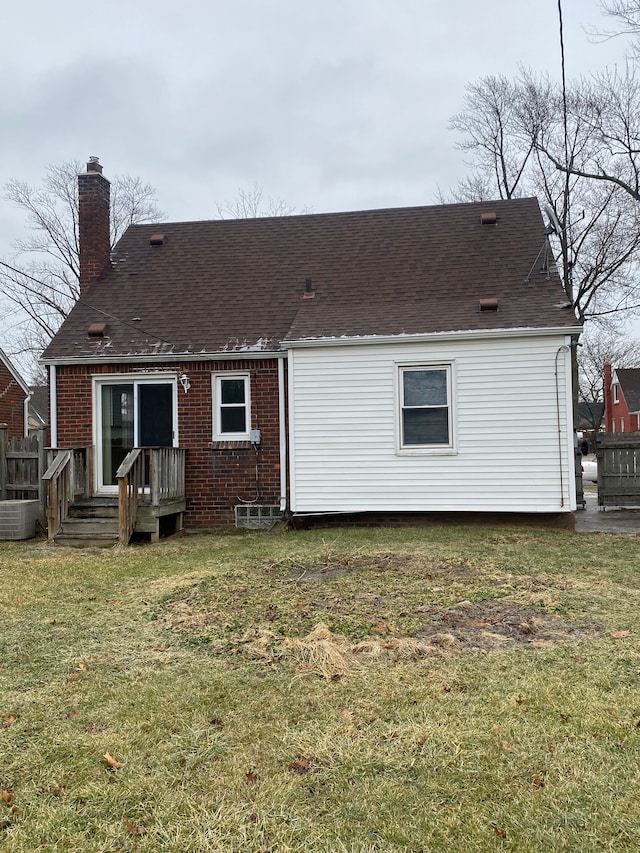 back of property featuring central AC and a yard