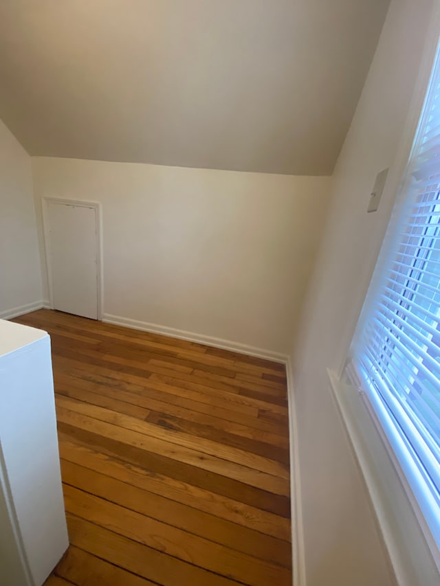 stairway featuring lofted ceiling and hardwood / wood-style floors