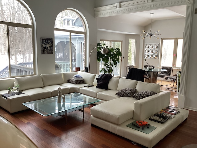 living room with dark hardwood / wood-style flooring, a notable chandelier, and a wealth of natural light