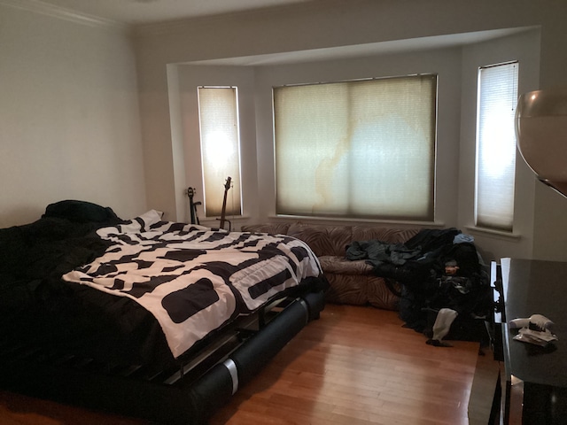 bedroom with hardwood / wood-style flooring and ornamental molding