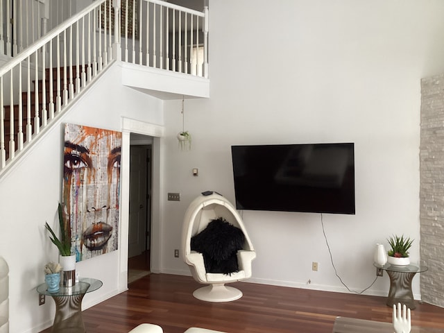 living room with dark wood-type flooring and a high ceiling