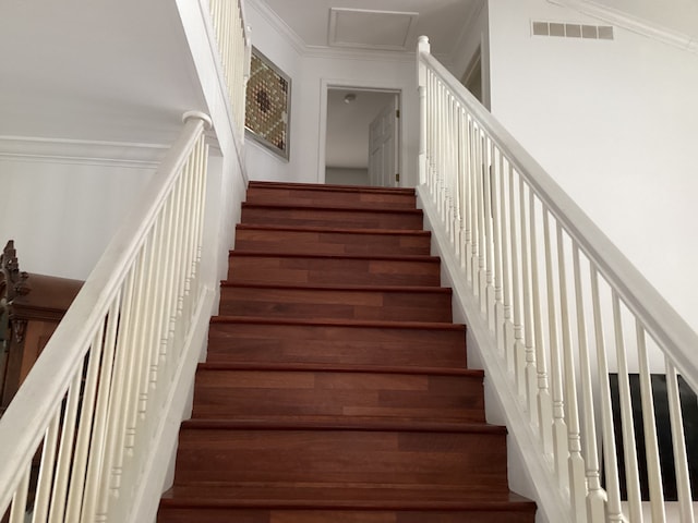 staircase with ornamental molding and wood-type flooring