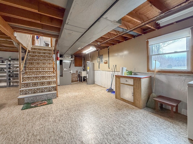 basement with sink, electric water heater, and heating unit