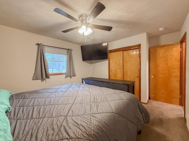 carpeted bedroom with a closet and ceiling fan