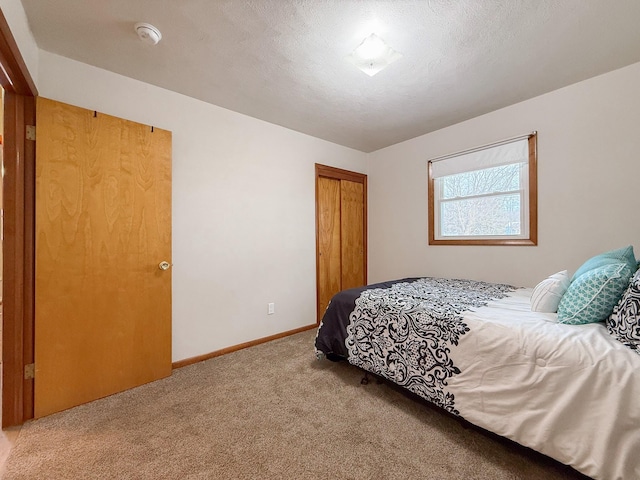 carpeted bedroom with a closet and a textured ceiling