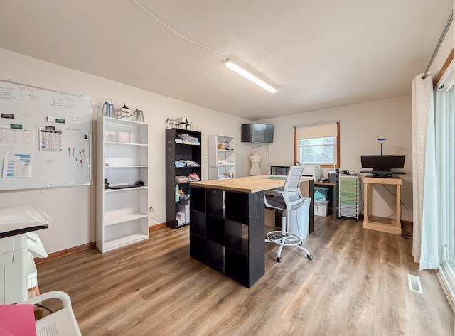 kitchen with a kitchen bar, wood-type flooring, wooden counters, and a kitchen island