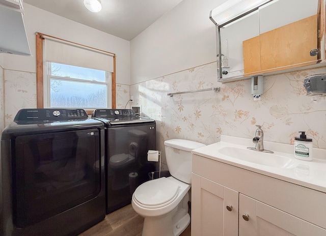 bathroom with vanity, toilet, washer and clothes dryer, and hardwood / wood-style floors