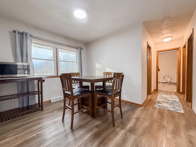 dining space with hardwood / wood-style floors