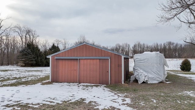 snow covered structure featuring a garage