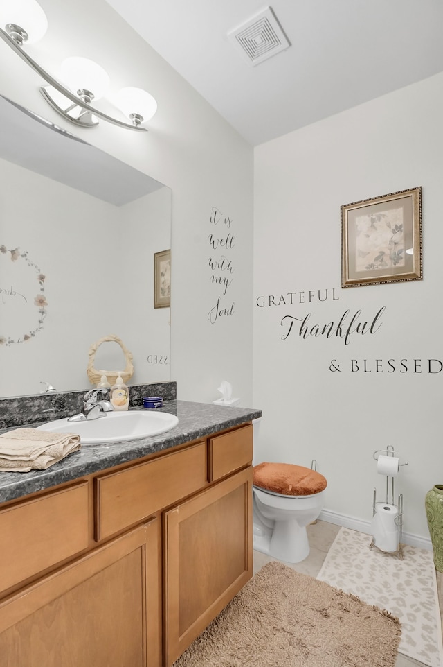 bathroom with vanity, tile patterned flooring, and toilet