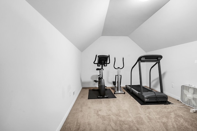 exercise room with lofted ceiling and light colored carpet