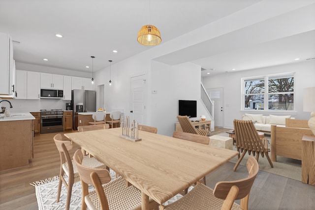 dining space featuring sink and light wood-type flooring