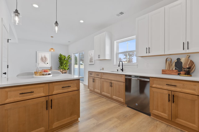 kitchen with dishwasher, sink, pendant lighting, and white cabinets