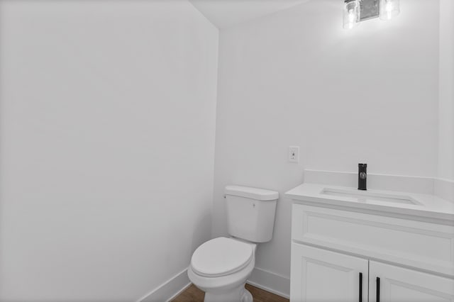 bathroom featuring vanity, hardwood / wood-style floors, and toilet