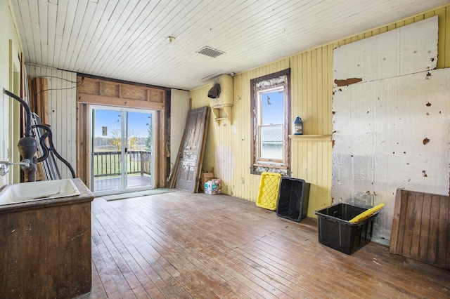 misc room featuring hardwood / wood-style flooring, wood ceiling, and wood walls