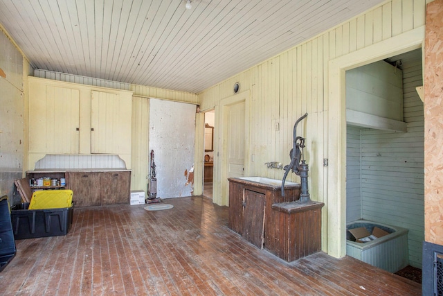 interior space featuring dark hardwood / wood-style flooring, sink, wooden ceiling, and wood walls