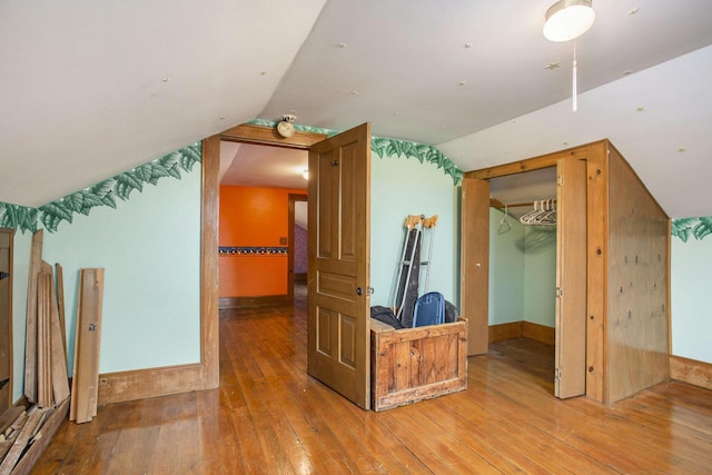 bonus room with vaulted ceiling and wood-type flooring