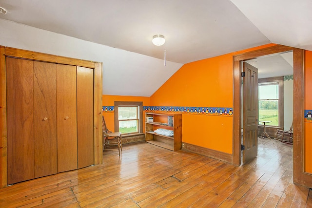 additional living space with vaulted ceiling and light wood-type flooring