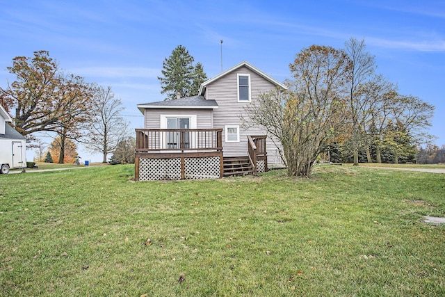 rear view of house with a wooden deck and a lawn