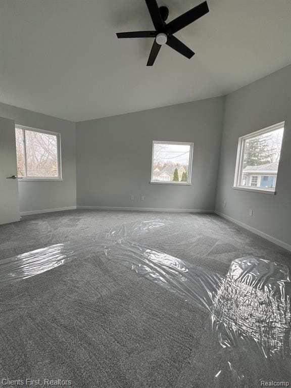 carpeted spare room with vaulted ceiling and ceiling fan