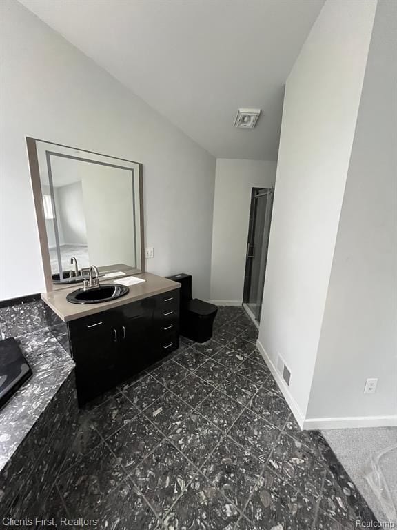 bathroom featuring vanity and vaulted ceiling