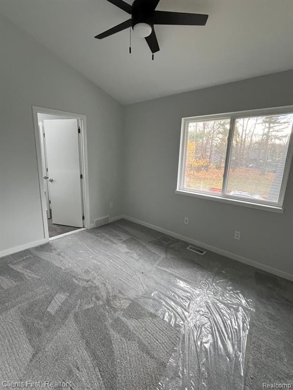 carpeted empty room featuring ceiling fan and lofted ceiling