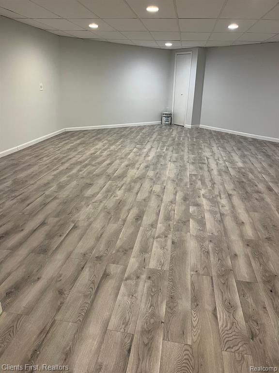 basement featuring light hardwood / wood-style floors and a drop ceiling