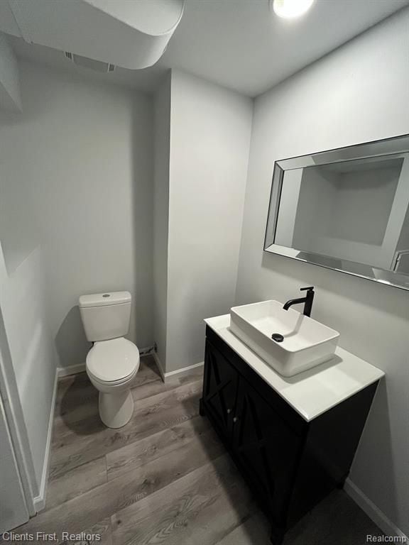 bathroom with vanity, toilet, and wood-type flooring