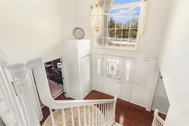 entrance foyer with a high ceiling, baseboards, dark wood finished floors, and a notable chandelier